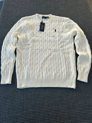 En vit stickad tröja av Polo Ralph Lauren  - En vit stickad tröja från Polo Ralph Lauren. Storlek L men passar bättre mer som M.                    Helt ny med prislapp. 