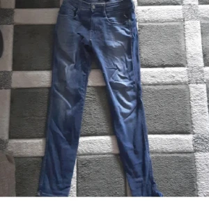 Replay Anbass blå jeans herr -    Replay Anbass Hyperflex jeans – nästan nya!  Säljer ett par Replay Anbass Hyperflex i riktigt bra skick, knappt använda då jag har flera andra par. Storlek: 32 längd, 29 midja. Superstretchigt och bekvämt material som är känt för att hålla formen och ge en perfekt passform.  Nypris ca 2000 kr jag säljer för 900.
