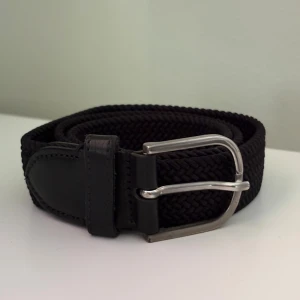 Saddler Flätat Bälte - Svart flätat bälte av märket Saddler! Bältet är 80 cm långt! Ny pris 700 kr! Priset är ej hugget i sten och vid frågor eller funderingar, tvivla inte på att höra av dig!
