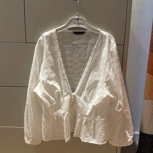 Vit blommig blus från Zara - Supersöt vit blus från Zara med broderade blommor och v-ringning. Säljer pga att den tyvärr inte kommer till användning!💕 Använd några få ggr😊 pris kan diskuteras