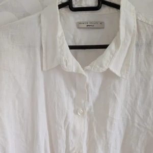 Vit oversized skjorta från Gina Tricot - Klassisk vit skjorta från Gina Tricot. Skjortan har lång ärm, knappar framtill och en avslappnad krage. Perfekt för en clean och fräsch look, lätt att styla till jeans eller shorts. Luftig och skön för varmare dagar.