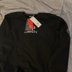 Svart sweatshirt från C.P. Company - Svart sweatshirt från C.P. Company, helt ny och i nyskick då den var för stor för mig, står XL men skulle säga att den sitter som L