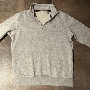 Grå half zip tröja från GANT - Säljer en snygg grå halfzip tröja från Gant. Tröjan är använda ganska många gånger men har inga defekter. Den är köpt på kidsbrandstore för ungefär 699. Den är i storlek 158-164 cm men den har blivit lite mindre i tvätten så den passar perfekt till någon som är mellan 155-160 cm lång. Om du har någon fundering är det bara att fråga så kommer jag med snabba svar.😀😄🙂