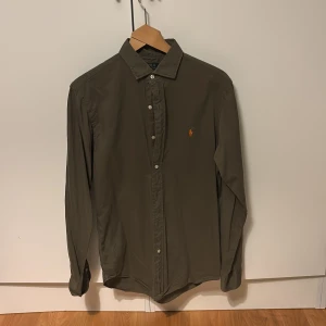 Olivgrön skjorta från Polo Ralph Lauren i storlek M - Riktigt snygg skjorta från Ralph lauren i färgen olivgrön och storlek M (slim fit). Den är i hyfsat bra skick 
