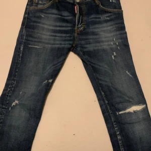 Dsquared2 blå slitna jeans - Blå Dsquared2-jeans i premiumstretchdenim med snygga slitningar och perfekt passform – lyxig streetwear som lyfter varje outfit.