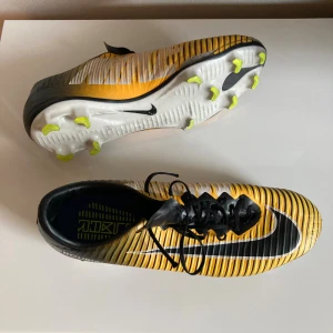  fotbollsskor gul svart -  fotbollssko,  etikett saknas  Osäker på storlek Jag köpte dem som storlek 43, verkar stämma   Sliten fram och på dobbarna  Vänster sko saknar snöre  Funkar annars bra