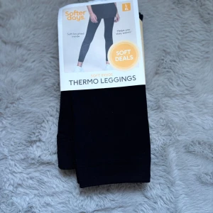 Svarta thermo leggings Softer Days - Svarta thermo leggings från Softer Days med mjuk borstad insida som håller dig varm. De är stretchiga och sitter tight, perfekta för kalla dagar. Materialet är en blandning av polyester och elastan för extra komfort och rörelsefrihet.