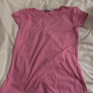 Rosa t-shirt från Zara, storlek S - Enkel och snygg rosa t-shirt från Zara i storlek S. T-shirten har rund halsringning och korta ärmar. Perfekt basic-plagg i mjukt material som passar till allt. Färgen är en härlig rosa nyans. har aldrig använts