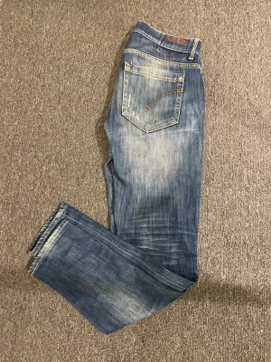 Dondup jeans - Säljer nu ett par sjukt feta Dondup jeans i den populära modellen George. Jeansen är blåa med sjukt snygga fades och slitningar. Priset är ej hugget i sten🪨‼️Storlek på jeansen är 32 men för säkerhets skull har ni mått nedan!                                                                           Längd: 102cm                                                           Midja: 40cm                                                              Hör av er om ni har några frågor!😁