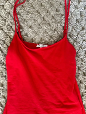 Röd linnetopp från Amisu - Säljer en röd linnetopp från Amisu i storlek S. Toppen har smala axelband och ärmlös design, perfekt för varma dagar. Materialet är mjuk bomull som känns skönt mot huden. Enkel och stilren modell som är lätt att matcha med olika outfits.