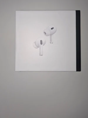 AirPods Pro (2nd generation) med MagSafe Charging Case (USB-C) - Säljer ett par AirPods Pro (2nd gen) med MagSafe-laddningsetui och USB-C. Hörlurarna och etuiet ser ut att vara i nyskick, med originalförpackning och skyddsplast kvar. Aktiv brusreducering och transparensläge för bästa ljudupplevelse.