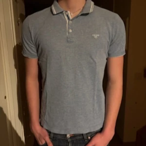 Blå piké från s.Oliver - Säljer en stilren blå piké från s.Oliver med klassisk krage och knappslå. Pikén har vita och blå ränder på kragen och är kortärmad. Perfekt för dig som gillar en enkel och snygg look till vardagen.