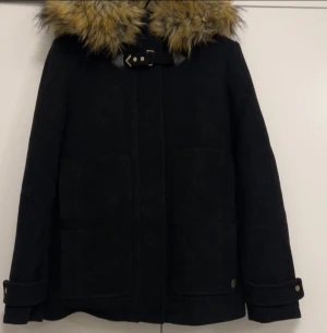 Pull & Bear jacka – strl L (passar M) - Snygg svart jacka från Pull & Bear med varm fuskpäls på huvan. Jackan är i storlek L men upplevs mer som en M i passformen. Klassisk och stilren modell som passar perfekt till höst och vinter. Mycket bra skick, sparsamt använd. Stängs framtill och har praktiska fickor.