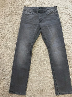 Jack jones  Slim Glenn grå jeans - Snygga grå jeans från Jack jones i slim fit- Slim Glenn modell. Har använts 2 gånger, så väldigt nya och oanvända. Perfekta i storleken och väldigt sköna. Sitter som storlekn säger och inga fel. PRIS KAN ALLTID DISKUTERAS 