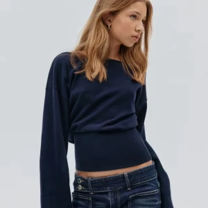 Marinblå stickad tröja  - Säljer en mörkblå stickad tröja med långa vida ärmar och v-ringad rygg. Tröjan har en tightare passform i midjan och är riktigt snygg till jeans. Andvänd en gång men säljer för den inte kommer till användning.