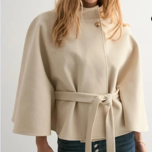 Beige poncho jacka  - Säljer denna beiga poncho jacka från Nelly som är helt slutsåld och ej går att få tag på längre. En väldigt elegant och stilrent jacka. ALDRIG använd och prislapp sliter kvar, därmed lite högre pris. Priset kan ev förhandlas om. Superfin och trendig nu till hösten🍂❤️