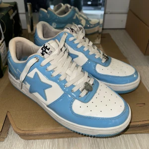 BAPE STA Baby blue - Säljer ett par BAPE STA sneakers i blankt skinn med blå och vita paneler. Skorna har klassisk stjärndesign på sidan, vita snören och perforerad tå. Snygg streetwear-vibe och riktigt fräsch färgkombo som sticker ut.