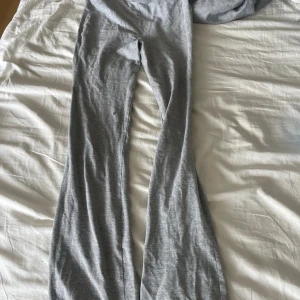 Grå bootcut mjukisbyxor från 157 - Mjuka och sköna grå mjukisbyxor från 157 i storlek XS. Byxorna har bootcut-modell med utsvängda ben och är tillverkade i ett stretchigt bomullsmaterial. Perfekta för en chill och avslappnad stil.