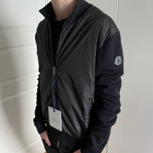 Moncler Cardigan Svart - Säljer en Moncler cardigan som är i bra skick! Har två små hål! Storlek M! Modellen på bilden är 176cm!  Hör gärna av dig om du har frågor! 