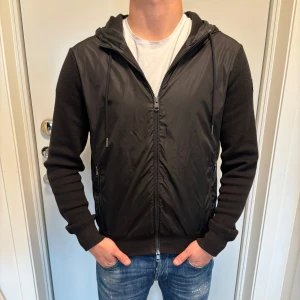 Svart cardigan Moncler - Svart stickad cardigan från Moncler. Storleken är L men passar M. Skicket är 7/10 lite tecken på användning.