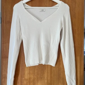 Vit topp - Säljer en stilren vit långärmad topp i storlek M. Toppen har  en snygg v-ringning. .