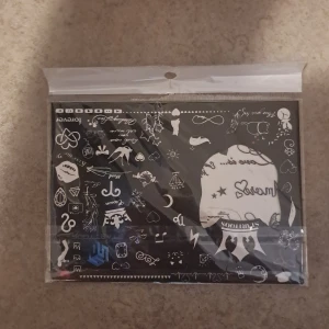 Svart ark med temporära tatueringar - Ett ark med temporära tatueringar i svart och vitt med motiv som hjärtan, stjärnor, texter och symboler. Perfekt för att skapa unika looks till ansikte eller kropp. Kommer i försluten plastförpackning och innehåller flera olika små motiv. "OANVÄNT"