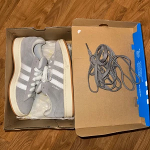 Adidas Campus (Grå) - Adidas campus skor i storlek 39. Kommer med box o.s.v. Är lite smutsiga efter användning men inget farligt. Skriv om ni har någon fråga