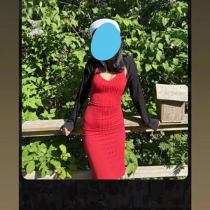 Röd ribbad klänning med v-ringning - Snygg röd ribbad klänning med v-ringning och figurnära passform. Klänningen är ärmlös och har en klassisk, stilren look som passar perfekt till student eller sommarens tillfällen.