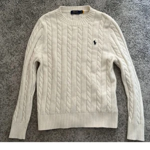 Polo Ralph Lauren kofta - Säljer en klassisk vit kabelstickad tröja från Polo Ralph Lauren med rund halsringning och broderad logga på bröstet. Tröjan har långa ärmar och ribbade muddar vid ärmslut och nederkant. Perfekt för lager-på-lager-stil. Väldigt bekväm och snygg näst intill nyskick. storlek s! Hör av dig vid frågor 🙌🏻