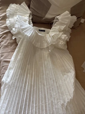 Vit plisserad volangklänning från Zara - Sjukt populär och eftertraktad klänning från Zara! 💓💓så fin att ha på studenten eller liknande!!  kontakta vid frågor annars är det bara att klicka på köp!!💓