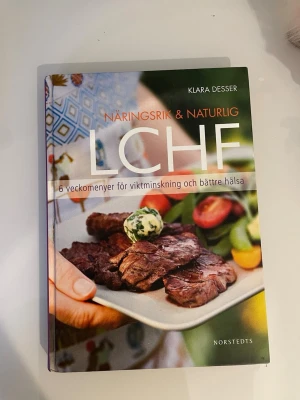 Näringsrik & naturlig LCHF bok - Säljer boken 'Näringsrik & naturlig LCHF' av Klara Desser. Innehåller 6 veckomenyer för viktminskning och bättre hälsa. Färgstark framsida med matfoto och tydlig titel. Perfekt för dig som vill testa LCHF och få inspiration till nya rätter.