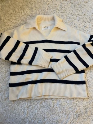 Randig stickad tröja från Zara💞🪽 - Snygg stickad tröja från Zara i krämvitt med marinblå ränder. Ribbstickade muddar och nederkant ger en klassisk look🩷