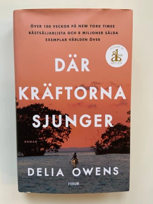 Där kräftorna sjunger av Delia Owens - En gripande roman om Kya Clark som växer upp ensam i North Carolinas våtmarker. Boken utforskar naturens krafter, utanförskap och överlevnad, med vackert omslag i orange toner och motiv av vatten och träd i solnedgång. Inbunden bok med tydlig titel och författarnamn. Vinnare av årets bok 2020 och blev även film. Superbra! Fint skick, bara lite vikt blad som rättar till sig när den ligger stängd. Mycket bra!