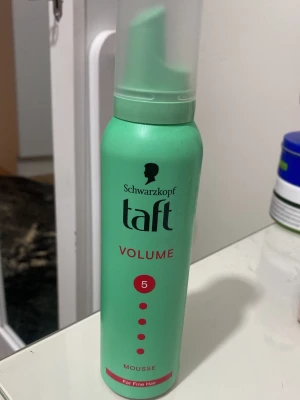 Schwarzkopf Taft Volume mousse - Volymmousse från Schwarzkopf Taft i grön flaska med röd text. Passar för fint hår och ger extra stadga (styrka 5). Perfekt för dig som vill ha mer volym och fyllighet i håret. Enkel att applicera med praktisk pump.