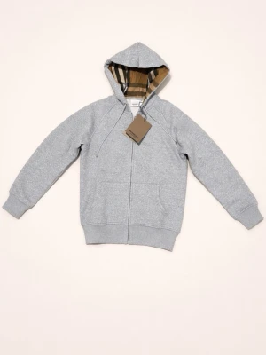 Burberry Zip-up hoodie Helt Ny!!! -  Upplev lyx och stil med denna exklusiva zip-up hoodie från Burberry. Tillverkad i mjuk, ljusgrå bomull med en bekväm passform i storlek M. Insidan av huvan pryds av Burberrys ikoniska rutmönster i beige, svart och vitt – en subtil men distinkt detalj som utstrålar elegans. Helt Ny!!!