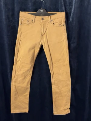 Levi's 511 beige jeans - Snygga beige Levi's 511 jeans med klassisk femficksdesign och raka ben. Jeansen har normal passform och är tillverkade i mjukt bomullsmaterial. Perfekta för dig som vill ha en clean och stilren look. Skriv för frågor. (Storlek 30/32) 
