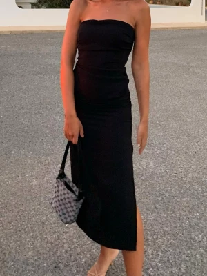 Svart axelbandslös klänning med slits - Snygg svart axelbandslös långklänning med slits på sidan. Köpt från Zara storlek XS