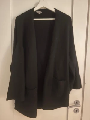 Svart kofta från Lindex, M - En svart, öppen kofta från Lindex i storlek M. Koftan har två framfickor och en avslappnad, lite oversized passform. 