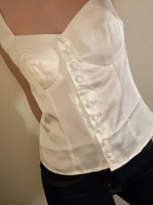 Korsett topp - Korsett liknande topp, går att knäppa upp helt. Aldrig använd, prislapp kvar. Storlek 34.