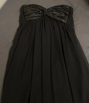 Svart axelbandslös klänning med paljetter - Perfekt för bal eller fest , aldrig använd 