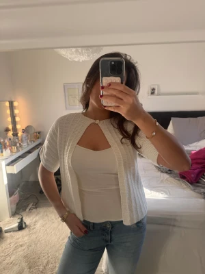 Vit ribbad kofta med kort ärm - Säljer en söt vit kofta med ribbat mönster och korta ärmar. Köpt secondhand därav de billiga priset. Skulle säga att de är storlek S💕