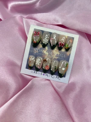 Jul 🎄 (M); Medium Almond - Säljer ett set handgjorda press-on naglar med julmotiv som snöflingor, polkagrisar, rosetter, julgranar och julkulor. Naglarna har nude bas och mörkgrön handmålad french, dekorerade med detaljer i rött, vitt, rosa och grönt. Perfekt för dig som vill ha extra festliga naglar under vintern.M: 16 mm, 12 mm, 12,5 mm, 11,5 mm, 10 mm