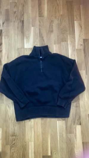 Svart stickad half zip tröja från Zara - Svart stickad tröja från Zara med half zip och hög krage. Tröjan har ribbade muddar vid ärmslut och nederkant, samt långärmad passform. Perfekt för dig som gillar en clean och chill look med lite oversized vibe. Tveka inte på att skriva vid frågor eller funderingar