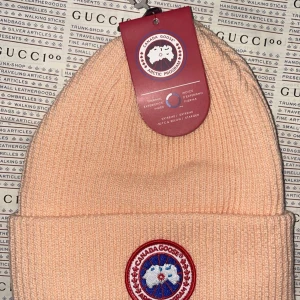 Canada goose vintermössa  - Helt ny Canada goose vintermössa i rött märke.mycket fin mössa speciellt i person. Onesize / unisex Finns i Göteborg annars frakt som alternativ. 