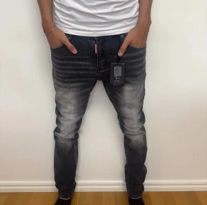 Dsquared2 jeans  - Säljer ett par helt nya svarta jeans från Dsquared2 med snyggt tvättad och sliten look. Jeansen har fem fickor, raka ben och klassisk passform. Materialet är jeans i bomull och de har märkets logga på bakfickan och fram vid gylfen.
