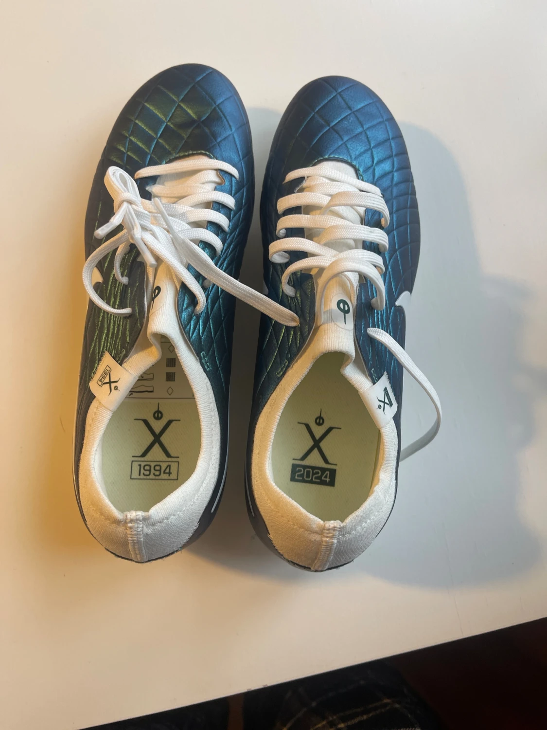 Detta är en fotbollssko av modellen Nike Tiempo Legend 10 Elite FG i en blå/grön iriserande färgvariant. - 4