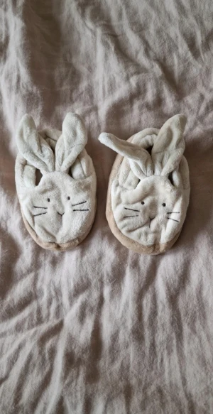 Beige kanin-tofflor med öron - Supergulliga beiga tofflor med kaninansikte och långa öron och en brun sula med tassmönster. Dom är noppriga på insidan, inga andra skavanker. Innermåttet är ca 9 cm och lapparna är bortklippta så jag kan inte säga något exakt. #kassfantasi62 #kassfantasi68