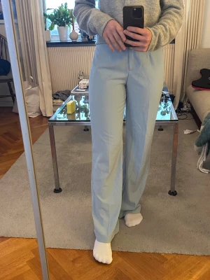 Ljusblå wide byxor från Bershka - Snygga ljusblå byxor från Bershka i storlek 38. De har en hög midja och vida/rak ben. Materialet är mjukt och lätt.