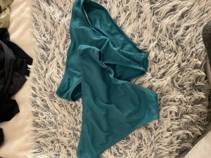 Turkos ribbad bikiniunderdel - Snygg turkos bikiniunderdel med ribbad struktur. Modellen har en klassisk form med medelhög midja och är tillverkad i ett stretchigt syntetmaterial som sitter skönt. Perfekt för strandhäng och pooldagar i sommar. Jag har för mig att de är ifrån H&M men är inte säker, 1 för 10 eller båda för 15kr. De är ej användna då de var för små för mig. Fler bilder kan skickas