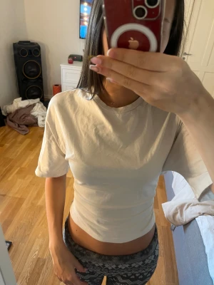 Vit croppad topp med knyt från Nelly - Säljer en vit croppad topp från Nelly i storlek S. Toppen har korta ärmar, rund hals och öppen rygg med snygg knytning bak. Tillverkad i mjuk bomull, perfekt för dig som gillar trendiga detaljer och vill visa lite rygg.